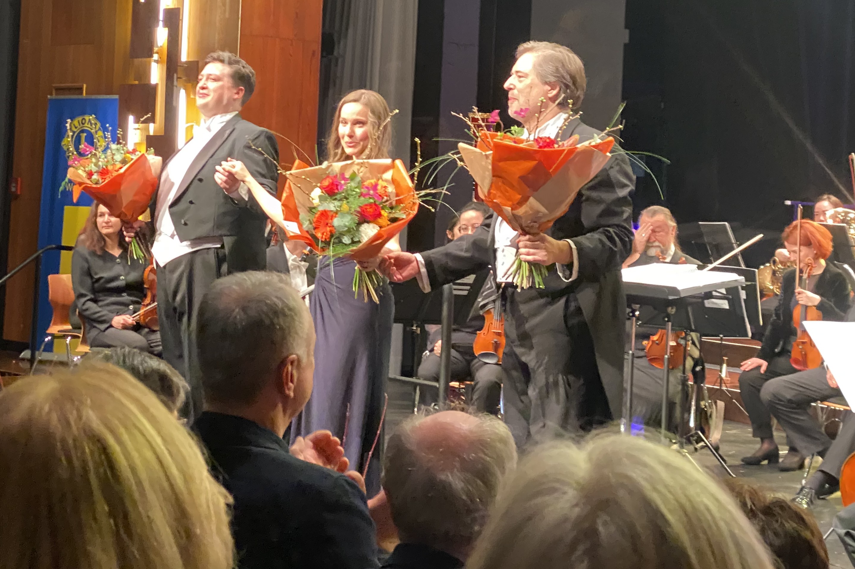 Blumen und stehende Ovationen: Leon Wepner (Tenor), Tanja Kuhn (Sopran) und Dirigent Alexander Steinitz (von links) nach dem Konzert.